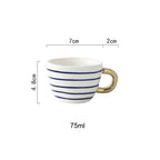 Tasse mit abstraktem geometrischem Muster und Goldhenkel