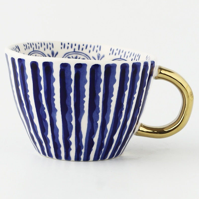 Tasse mit abstraktem geometrischem Muster und Goldhenkel