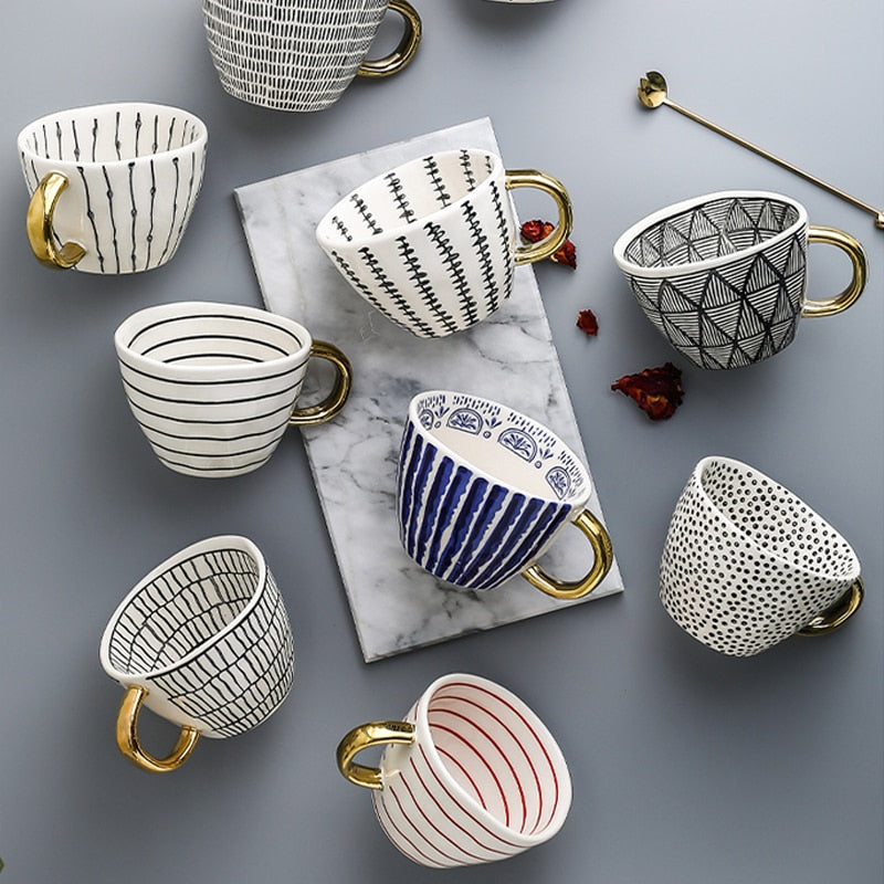 Tasse mit abstraktem geometrischem Muster und Goldhenkel