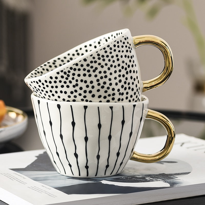 Tasse mit abstraktem geometrischem Muster und Goldhenkel