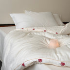 Quilt made of cotton satin with embroidered rose trim