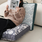 Padded floor cushion with quilted tufting, floral motif and carrying handle
