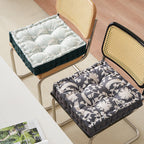 Padded floor cushion with quilted tufting, floral motif and carrying handle